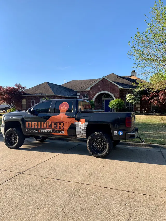 The wrapped Driller Roofing and Construction work truck parked outside a completed Tulsa home